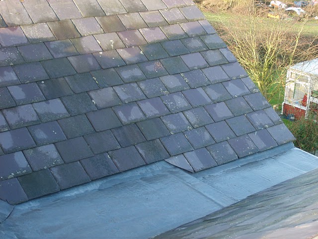 A newly finished slate roof meeting a flat roof, laid by Fletcher & Co Roofing